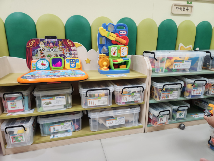 다양한 종류의 블럭들이 개월 수에 맞는 안내와 함께 진열장에 놓여있다.