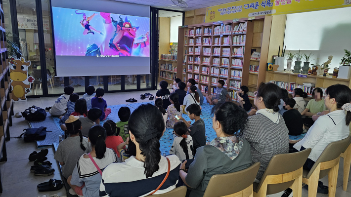 지역아동센터 아이들이 우만1동 새마을문고에서 영화를 보고 있다.