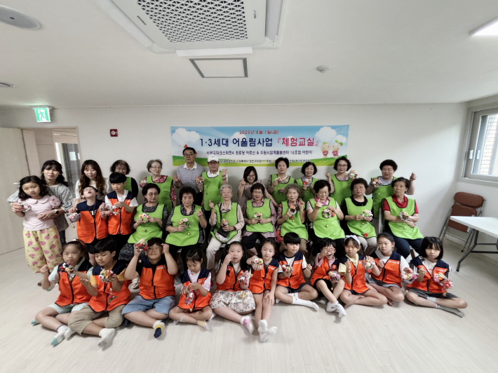 [어르신들과 아이들이 함께 만든 도어벨을 들고 기념사진을 찍는 장면]  