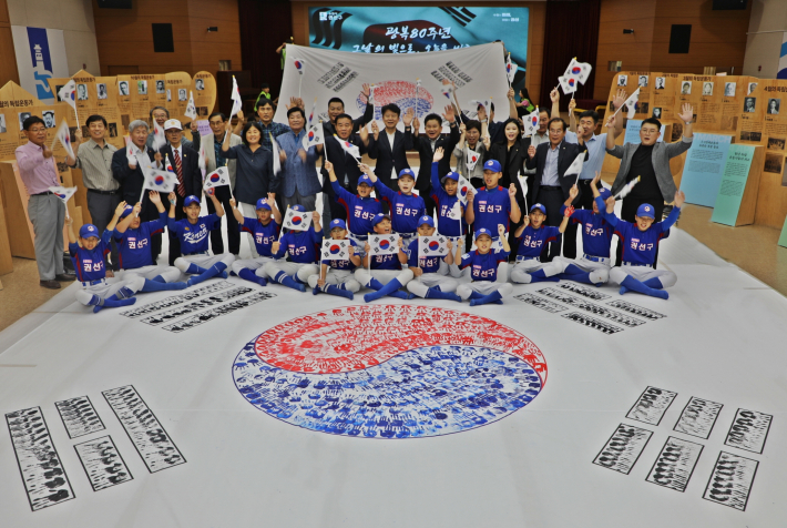 사진6) 권선구가 광복 80주년을 맞아 지역 주민들과 함께 대형 손바닥 태극기를 제작한 뒤 기념촬영을 하고 있다.    