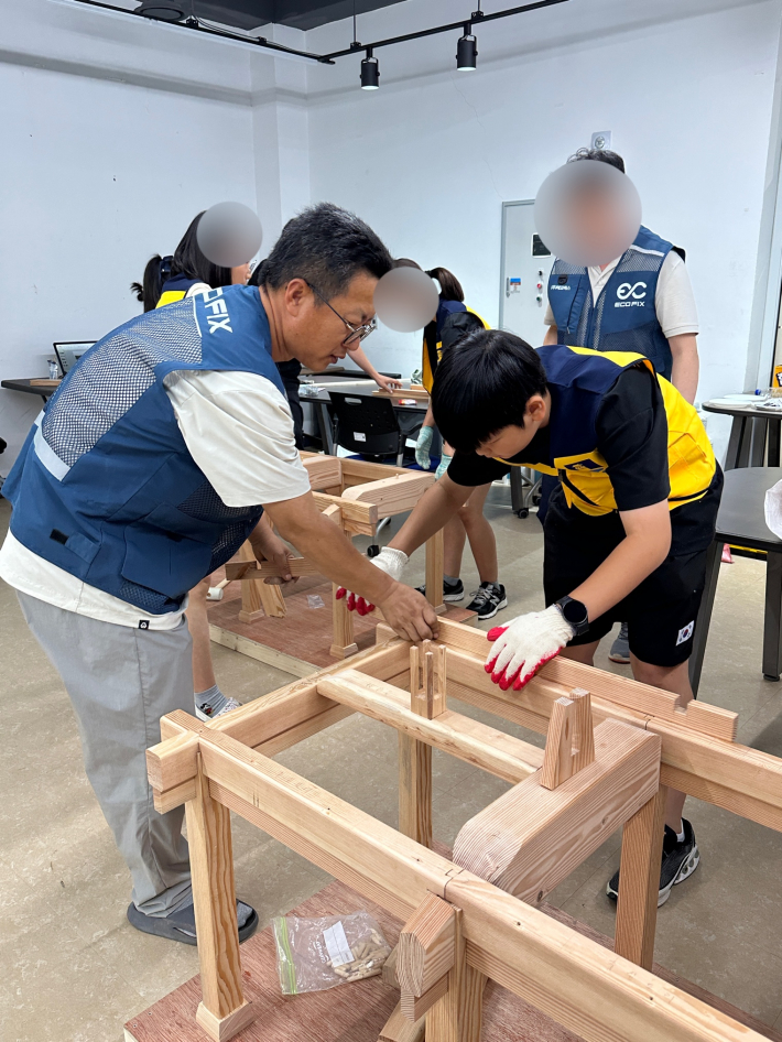 조립한 미니어처 한옥을 참가 학생이 해체하고 있다.