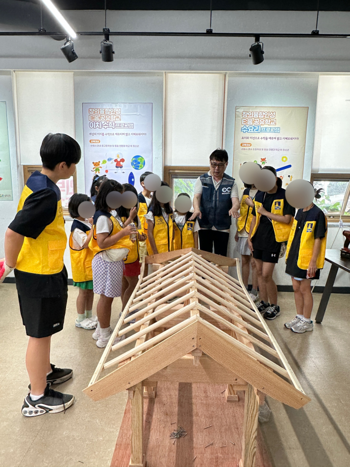 조립을 마친 후 전문강사가 학생들에게 한옥의 주요 구조에 대해 설명하고 있다.
