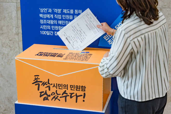 한 시민이 '폭싹 담았수다! 시민의 민원함 신청서'를 작성한 뒤 수원시청에 설치된 민원함에 넣고 있다.