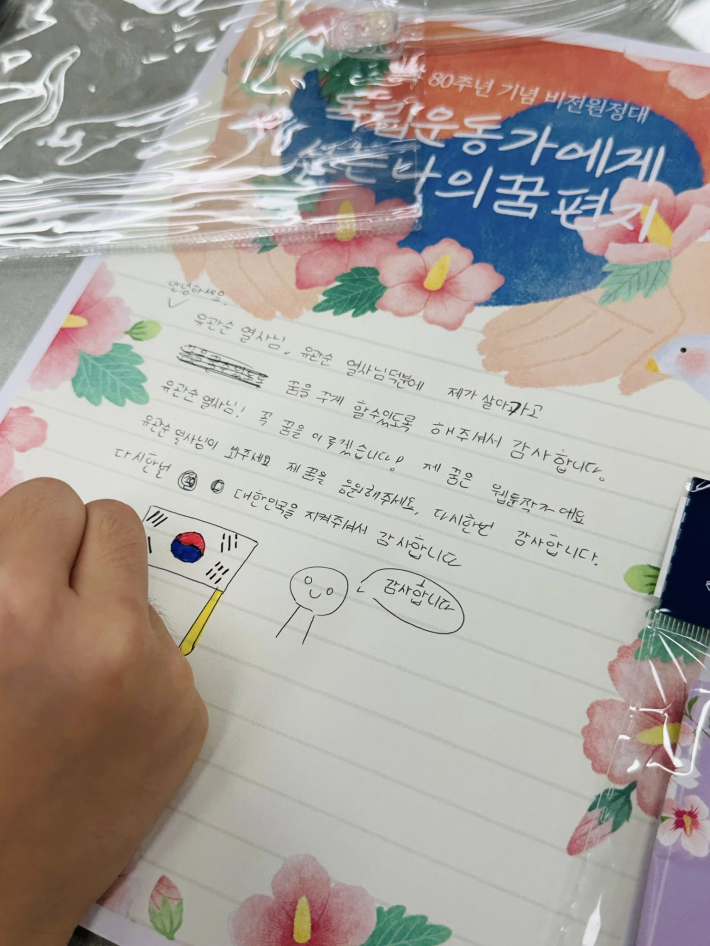 아이가 독립운동가에게 감사의 마음을 담아 편지를 쓰고 있다. 
