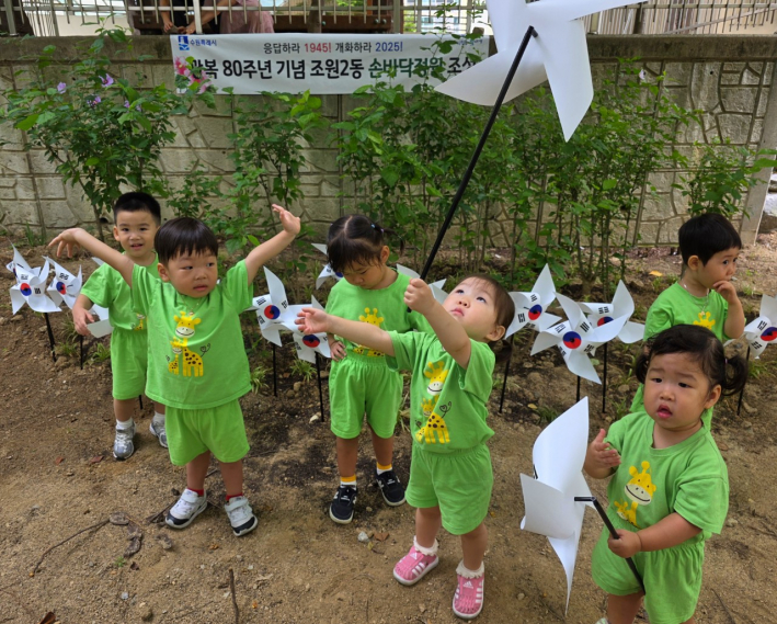 손바닥정원에 태극기 바람개비를 꽂고 있는 아이들