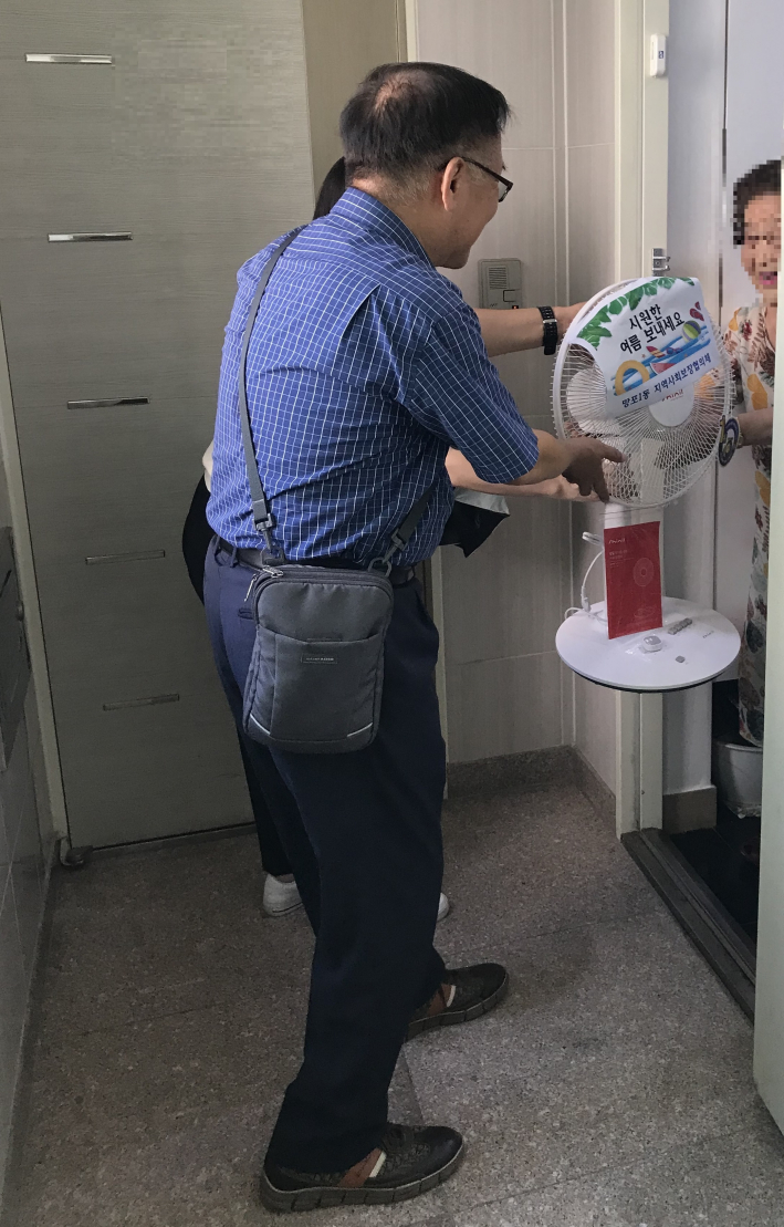 망포1동 지역사회보장협의체 위원들이 가정방문하여 안부를 확인하며 선풍기를 전달하고 있다