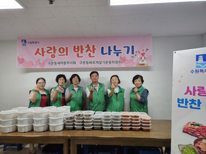 구운동 새마을부녀회 회원들이 직접 만든 반찬과 함께 사진을 찍고 있다.