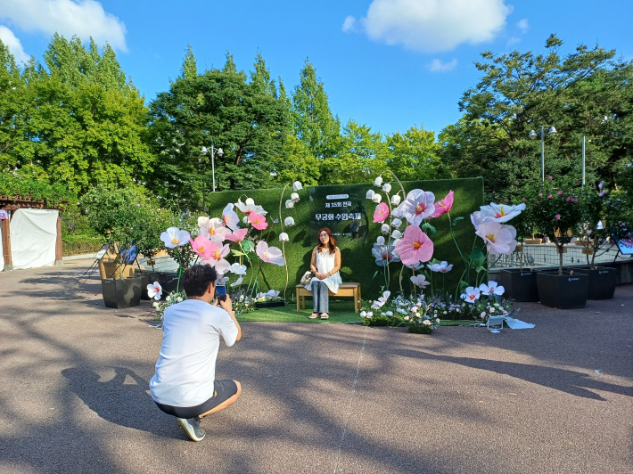 무궁화 포토존에서 남편이 아내의 아름다운 모습을 찍는 전경 