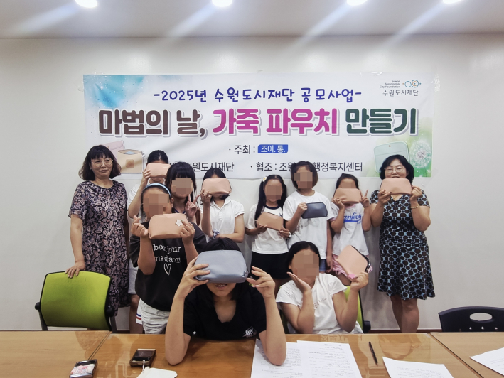 조이통 회원들과 아이들이 직접 제작한 가죽 파우치를 들고있다