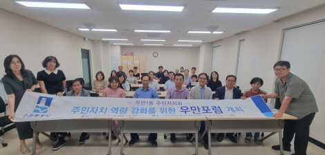 우만1동 주민자치회 위원들이 '우만포럼' 종료 후 단체사진을 촬영하고 있다.