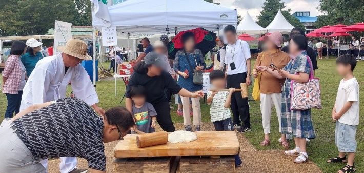 어린이가 떡메체험을 하고 있다.
