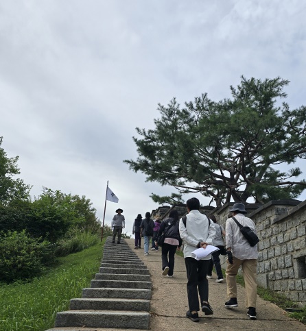 가을 햇살 속 수원화성을 걸으며 역사여행을 즐기는 시민들