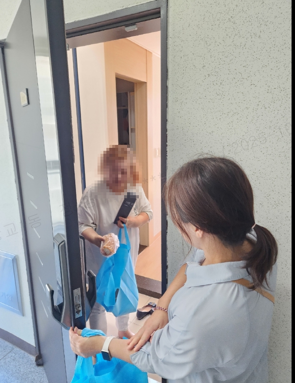 어르신에게 빵 전달하는 사진입니다