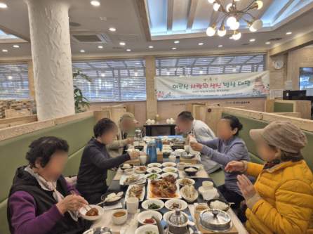 어르신들이 이교수 한정식 식당에서 식사를 하고 있다. 