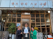 광교2동장(우)과 광교2동 지역사회보장협의체 위원장(좌)이 ‘사랑나눔수원’ 현판을 샌프란시스코국밥에 전달하는 모습.