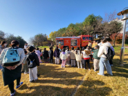 어린이들이 소방관의 안전교육 설명을 들으며 소방차를 가까이에서 관찰하는 모습.