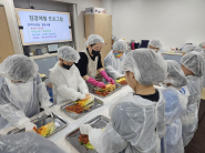 수원시다함께돌봄센터11호점 아동들이 선생님의 안내에 따라 절임배추에 김칫속을 넣으며 김장 체험에 참여하고 있다.