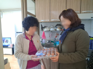 노인맞춤돌봄서비스 대상 어르신에게 계란을 전달하고 있다.