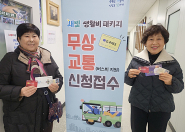 버스 교통비 무상 지원 신청 방법을 묻자, 현장에 나온 통장들이 저금통장과 주민등록증, G-Pass 카드를 하나하나 직접 보여주며 어르신들에게 밝은 미소로 설명하고 있다.