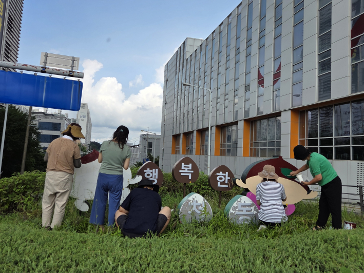 율천동 지킴이 봉사단 단원들이 밤 조형물에 색을 칠하고 있다.