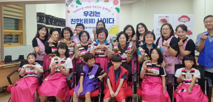 다문화 아동과 평동 경로당 어르신이 전통의상을 입고 포즈를 취하고 있다