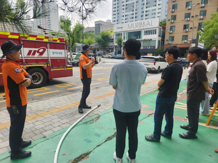 영통1동 직원들이 영통119안전센터 교관의 설명을 듣고 합동 소방훈련 진행중인 모습