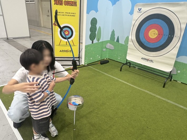 양궁 체험존에서 활을 겨누는 아이 모습. 과녁을 향한 집중력이 대단했다.