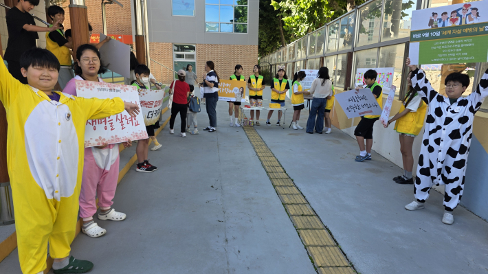 수원 지동초 학생자원봉사단원이 등굣길 전교생 맞이하며 캠페인을 하고 있다.