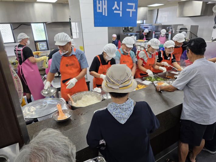 수원소방서 및 장안여성의용소방대가 배식 봉사활동을 통해 어르신들과 소통하며 식사를 돕고있다.