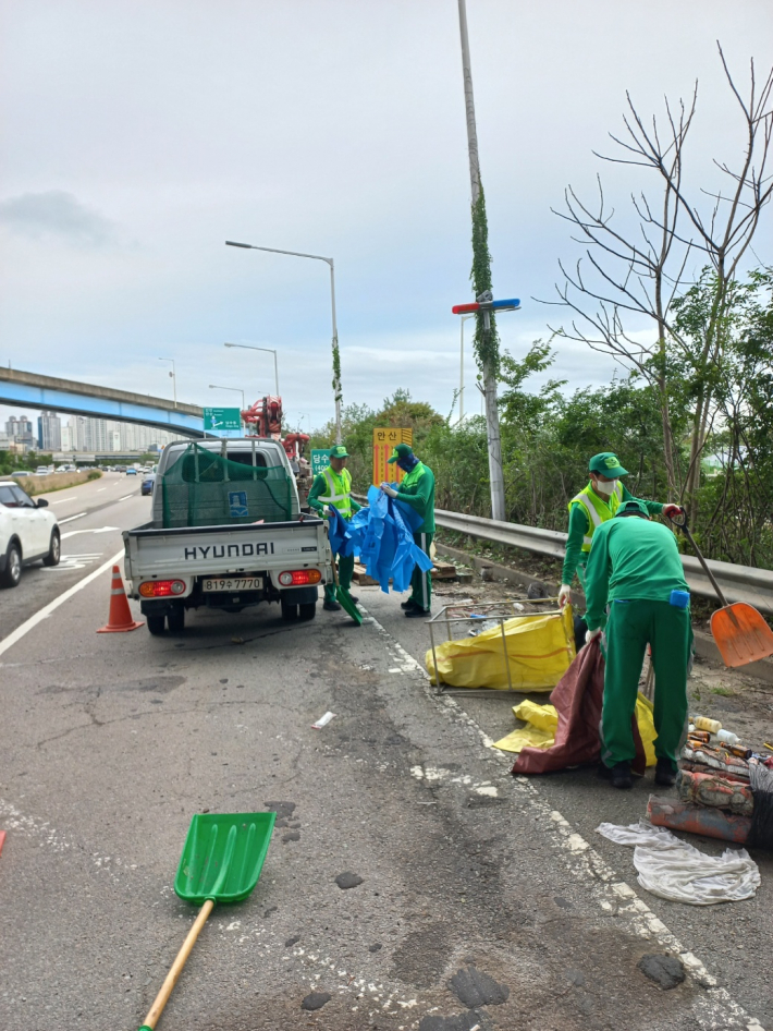 권선구 및 입북동 소속 환경관리원들이 수인산업도로 주변 갓길을 정비하고 있다.