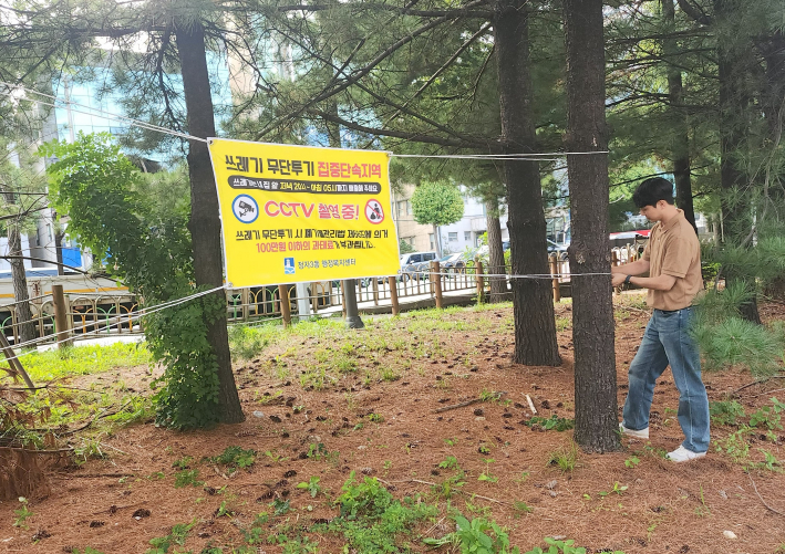 무단투기 근절 현수막을 거는 사진
