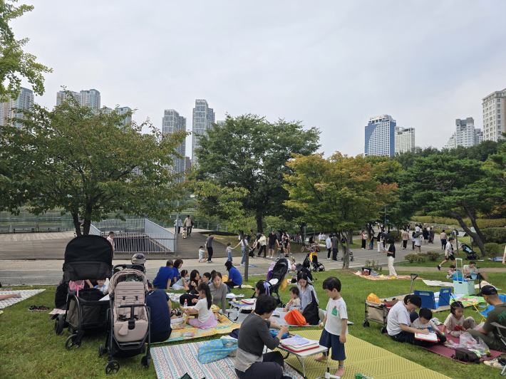 가족들과 함께 잔디밭에 앉아 그림을 그리고 있는 대회 참가자들