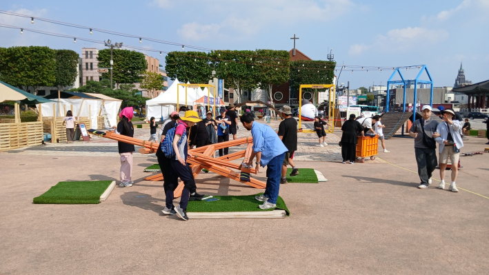 성인들이 여러시소 놀이하는 장면