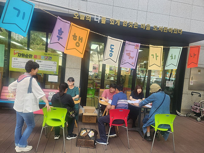 조원1동 새마을문고 앞에서 리유저블백 증정행사를 실시하고 있다 