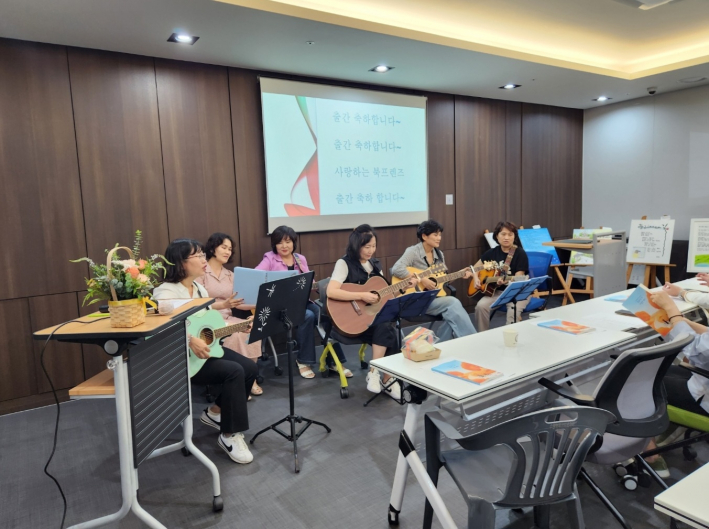 수원역푸르지오자이아파트 기타동호회 회원들이 흥겨운 노래로 <물감으로 쓴 가을빛 편지> 시화전 기념행사를 응원학고 있다