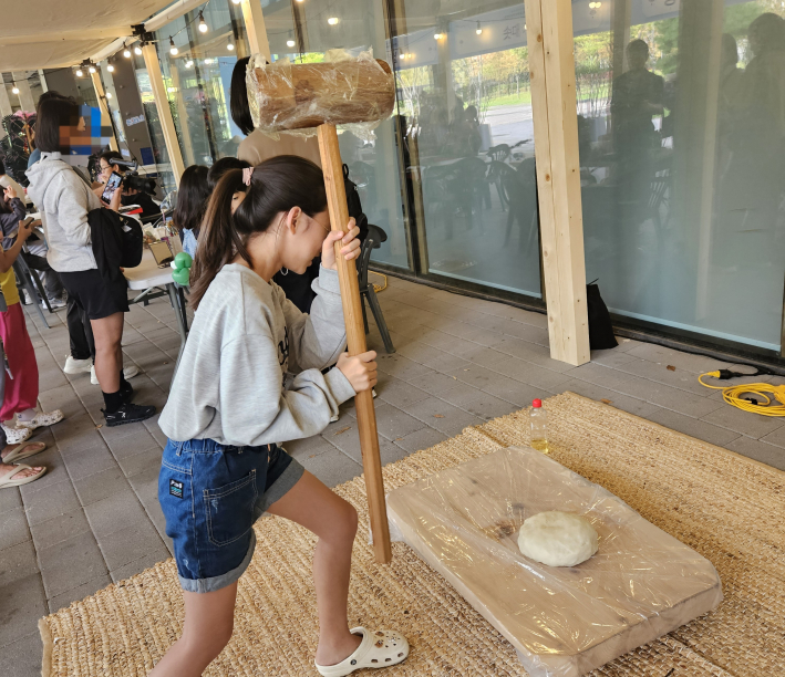 떡메치기 체험 중인 어린이