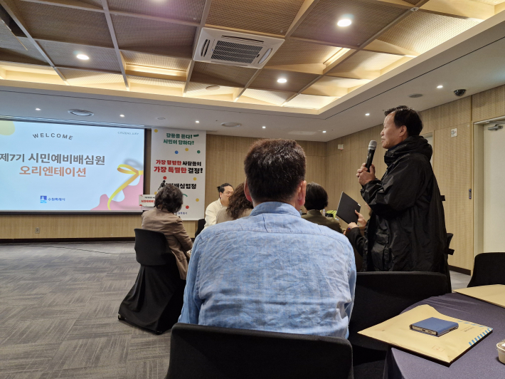 질의응답 시간에 시민 예비 배심원이 질문하고 있다.