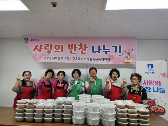 구운동 새마을부녀회 회원들이 직접 만든 반찬과 함께 사진을 찍고 있다.