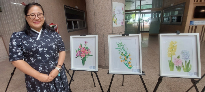 정선미 회원이 자신과 회원들 작품 앞에 섰다.