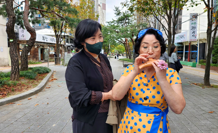 거리공연을 관람하던 박복순(65) 시민이 오카리나 독주에 흥미를 가지며 사진촬영을 하고 있다.