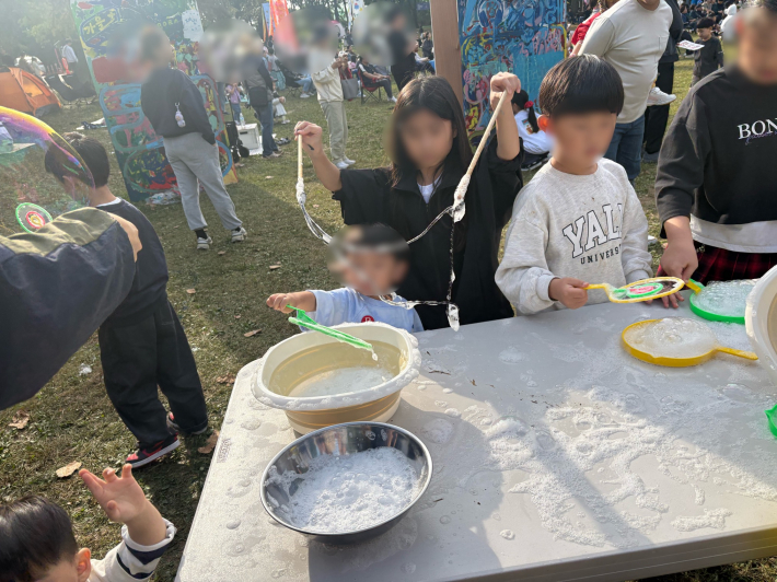 햇살에 반짝이는 비누방울 속을 뛰노는 아이들. 웃음과 반짝임이 어우러진 해방의 장면.