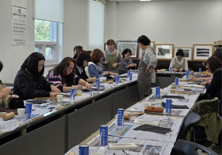 화서2동 새마을문고 특성화수업 수강생들이 가죽 공예를 직접 만들고 있다.