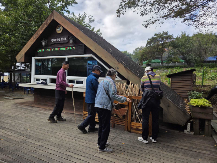 사진)등산객들이 광교산 등산 안내소 앞에 있는 지팡이를 고르고 있다.    