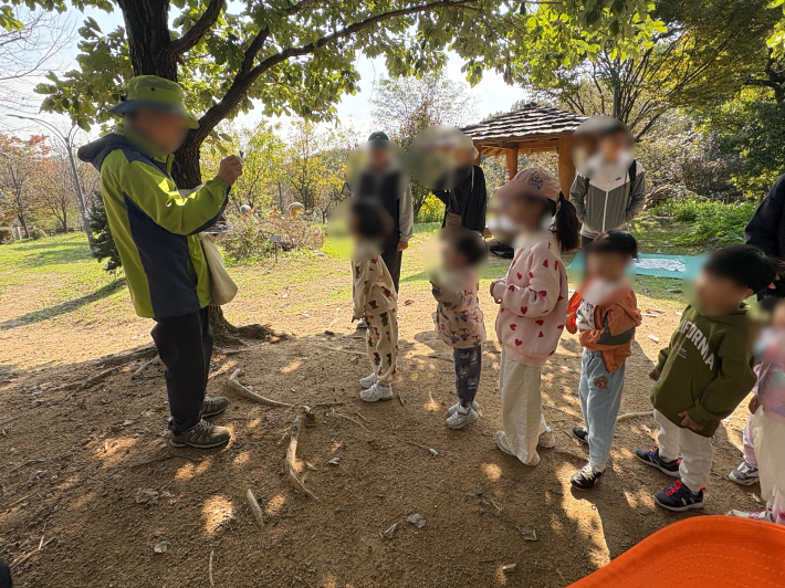 도꼬마리를 멧돼지 그림에 던지기 위해 줄을 선 아이들의 모습.