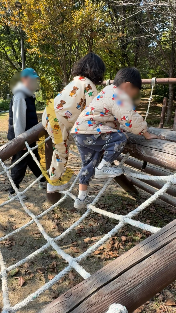 놀이터에서 줄을 타며 위로 올라가는 아이의 모습.