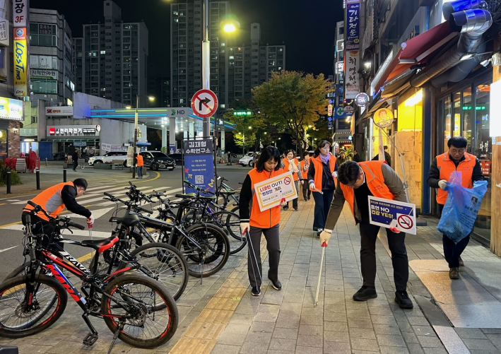 주민자치회 위원들이 상가 주변에서 담배꽁초를 수거하고 있다.