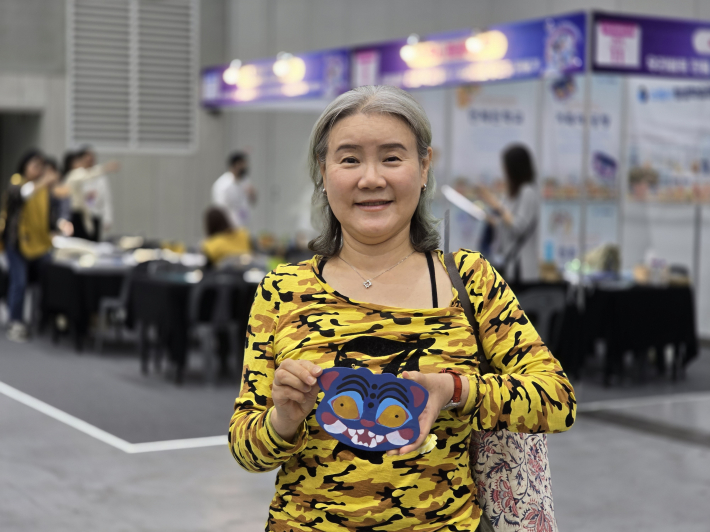 수원시 평생학습축제 수원시평생학습관 부스에서 '케데헌 호랑이 나무 컵받침 만들기' 체험에 참여한 시민이 직접 완성한 호랑이 컵받침을 들어 보이고 있다.