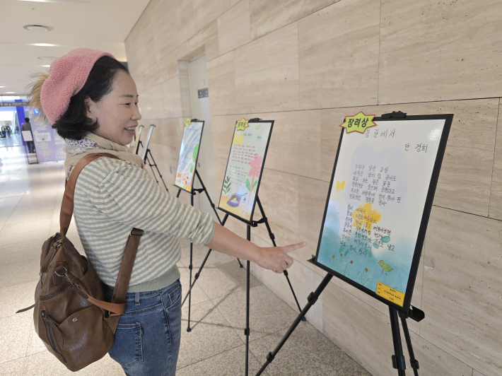 평생학습 참여자들의 작품이 전시된 시화전을 시민이 관람하고 있다.