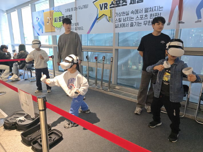 아이들이 VR 헤드셋을 착용하고 가상현실 속 스포츠 경기를 즐기고 있다.