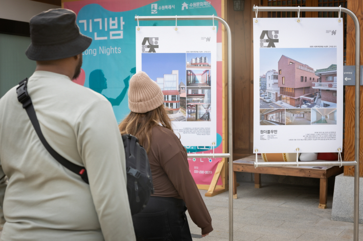 사진1) 지난 10월30일 2025 수원도시건축문화제가 열린 수원시 정조테마공연장에서 외국인들이 2025 수원디자인대상 작품 사진을 감상하고 있다.    